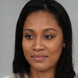 Joyful black adult female with long  brown hair and brown eyes