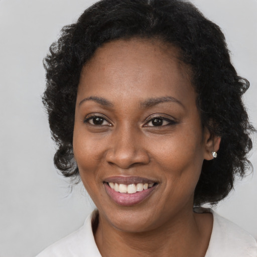 Joyful black adult female with short  brown hair and brown eyes