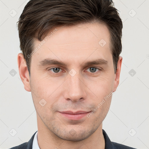 Joyful white young-adult male with short  brown hair and grey eyes