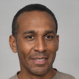 Joyful black adult male with short  black hair and brown eyes