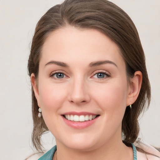 Joyful white young-adult female with medium  brown hair and grey eyes