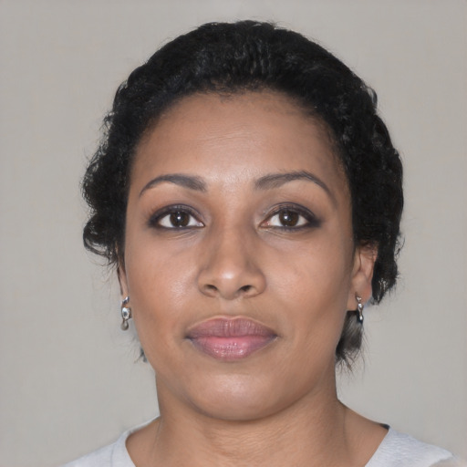 Joyful black young-adult female with short  black hair and brown eyes