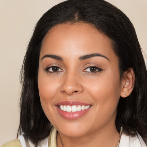 Joyful latino young-adult female with long  black hair and brown eyes