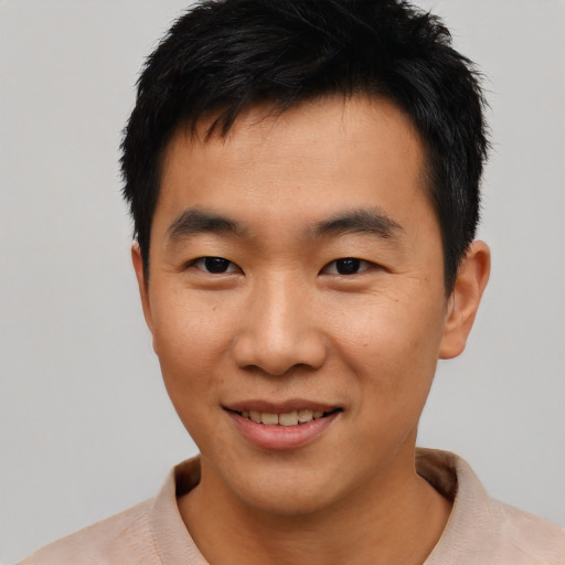 Joyful asian young-adult male with short  black hair and brown eyes