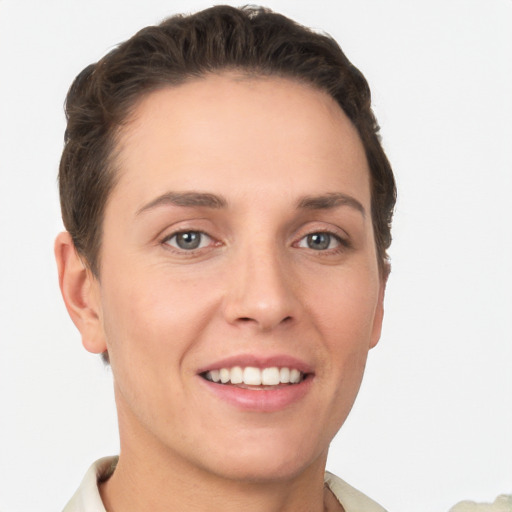 Joyful white young-adult female with short  brown hair and grey eyes