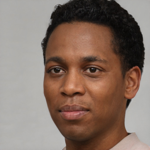 Joyful black young-adult male with short  black hair and brown eyes