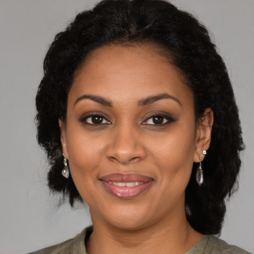 Joyful black young-adult female with medium  brown hair and brown eyes