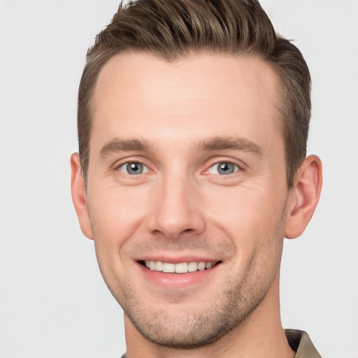 Joyful white young-adult male with short  brown hair and grey eyes