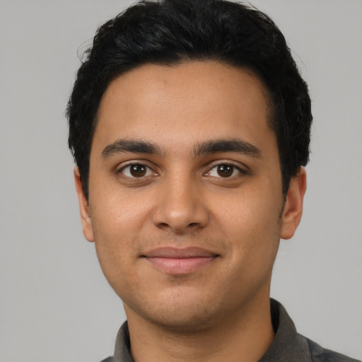 Joyful latino young-adult male with short  black hair and brown eyes