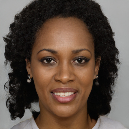 Joyful black young-adult female with medium  brown hair and brown eyes