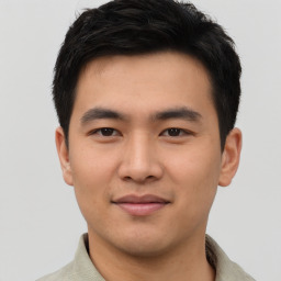 Joyful asian young-adult male with short  black hair and brown eyes