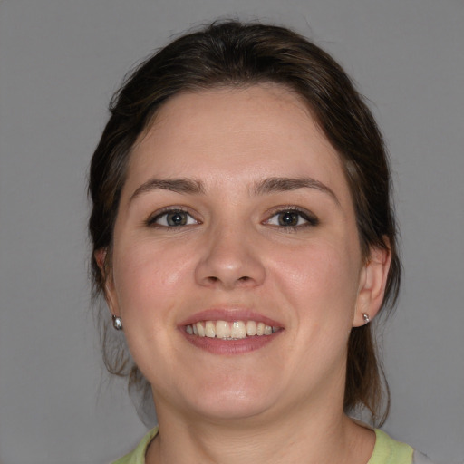 Joyful white young-adult female with medium  brown hair and grey eyes