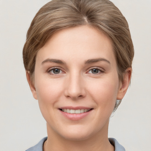 Joyful white young-adult female with short  brown hair and grey eyes