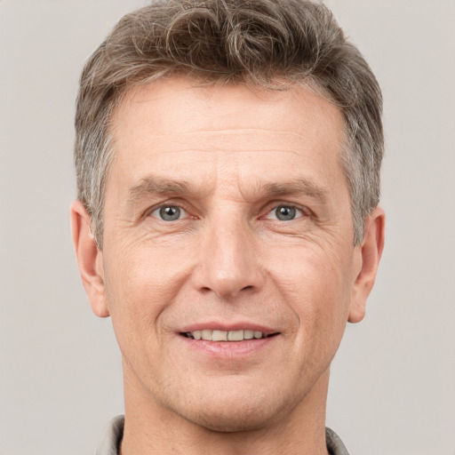 Joyful white adult male with short  brown hair and grey eyes