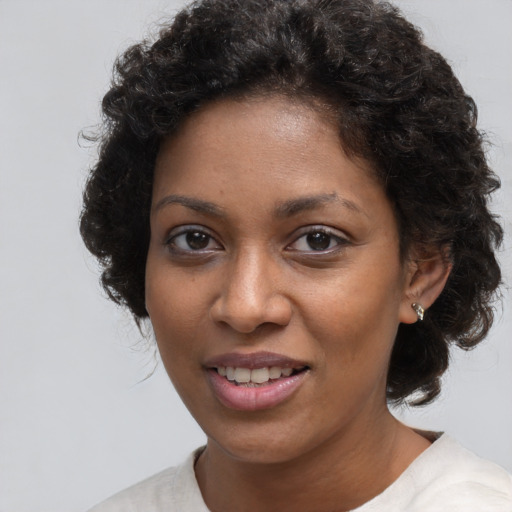 Joyful black young-adult female with short  brown hair and brown eyes