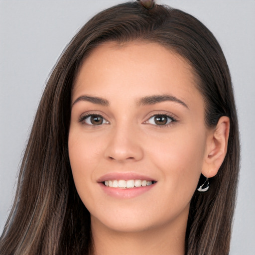 Joyful white young-adult female with long  brown hair and brown eyes