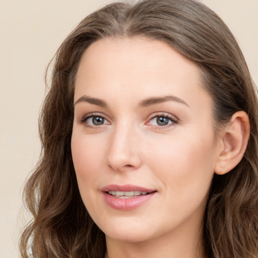 Joyful white young-adult female with long  brown hair and blue eyes