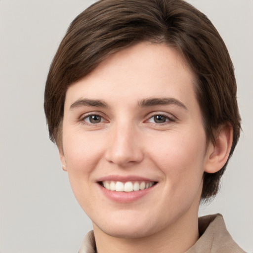 Joyful white young-adult female with short  brown hair and grey eyes