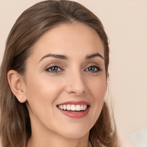 Joyful white young-adult female with long  brown hair and brown eyes