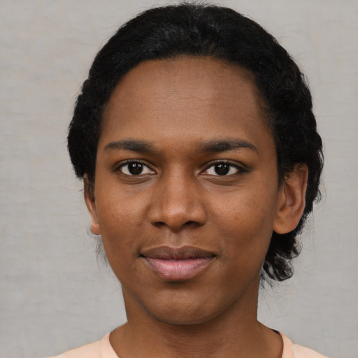Joyful black young-adult female with short  black hair and brown eyes