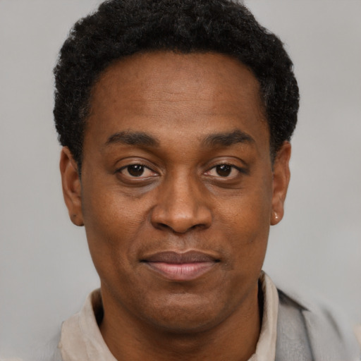 Joyful black adult male with short  black hair and brown eyes