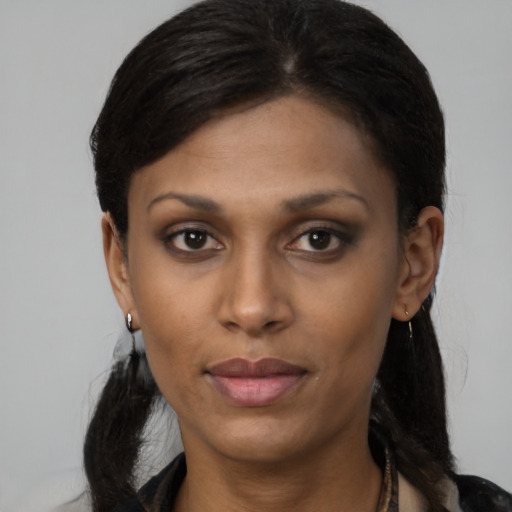Joyful black young-adult female with medium  brown hair and brown eyes