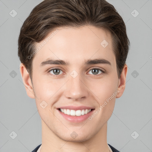 Joyful white young-adult male with short  brown hair and grey eyes