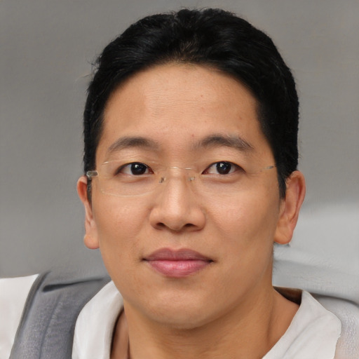 Joyful asian adult male with short  brown hair and brown eyes