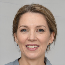 Joyful white adult female with medium  brown hair and grey eyes