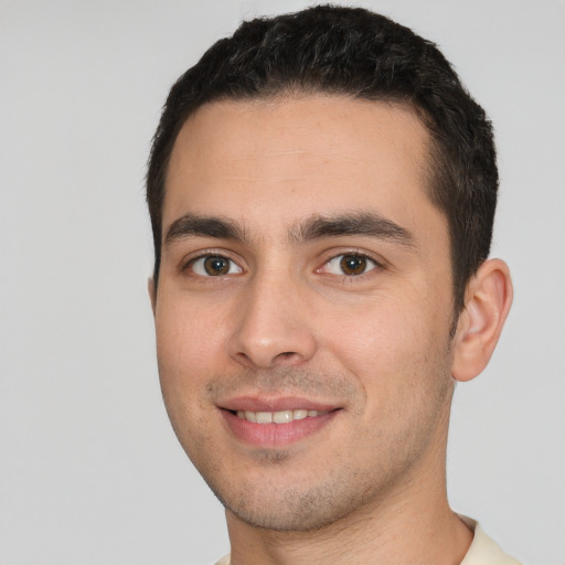 Joyful white young-adult male with short  black hair and brown eyes