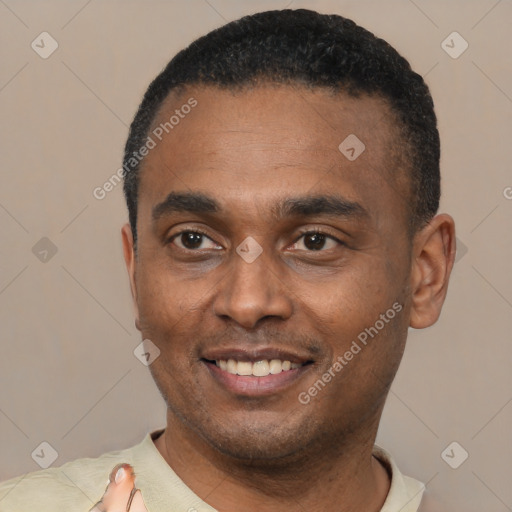 Joyful black young-adult male with short  black hair and brown eyes