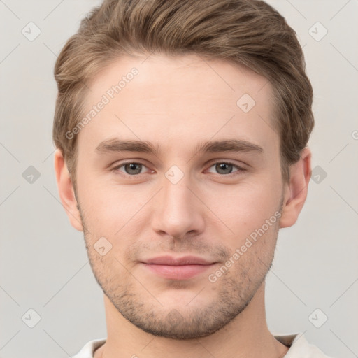 Joyful white young-adult male with short  brown hair and grey eyes