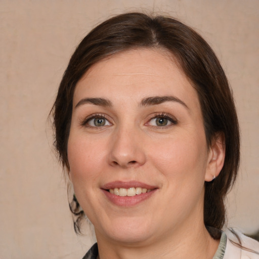 Joyful white young-adult female with medium  brown hair and green eyes