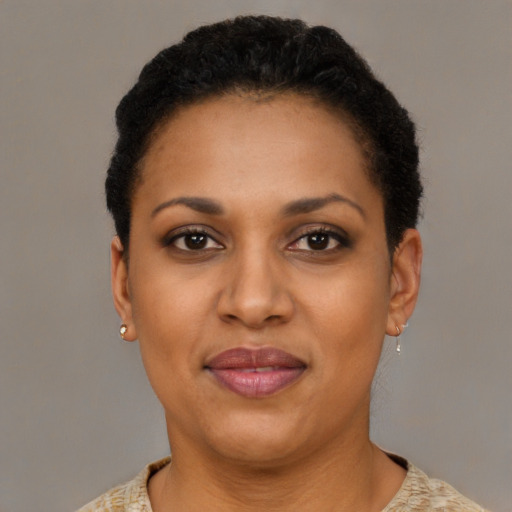 Joyful black young-adult female with short  black hair and brown eyes