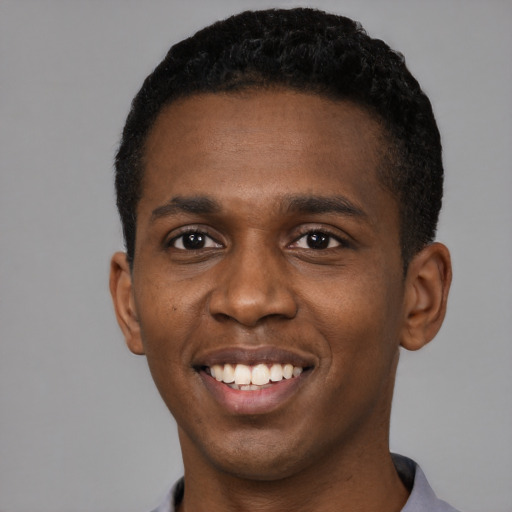 Joyful black young-adult male with short  black hair and brown eyes