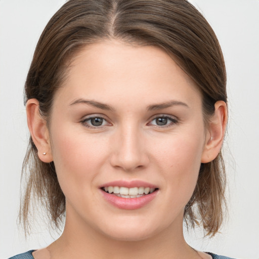 Joyful white young-adult female with medium  brown hair and grey eyes