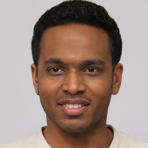 Joyful black young-adult male with short  black hair and brown eyes