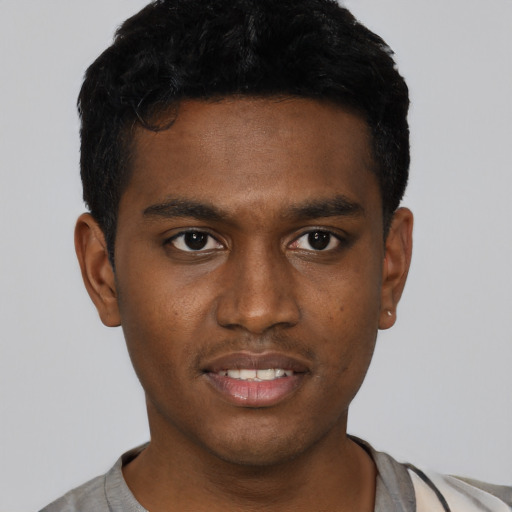 Joyful black young-adult male with short  black hair and brown eyes