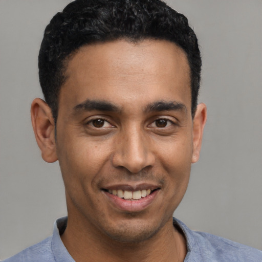 Joyful latino young-adult male with short  black hair and brown eyes