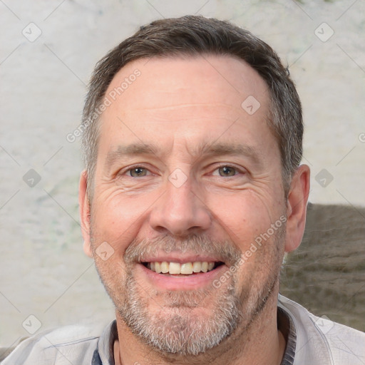 Joyful white adult male with short  brown hair and brown eyes