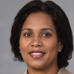 Joyful black adult female with medium  brown hair and brown eyes