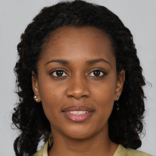 Joyful black young-adult female with long  black hair and brown eyes