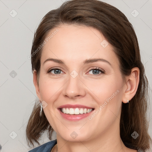 Joyful white young-adult female with medium  brown hair and grey eyes