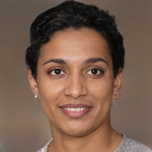 Joyful black young-adult female with short  black hair and brown eyes