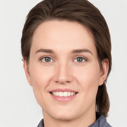 Joyful white young-adult female with medium  brown hair and grey eyes