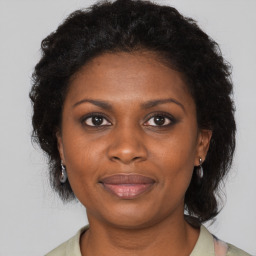 Joyful black adult female with medium  brown hair and brown eyes