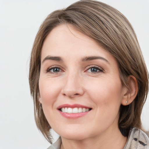 Joyful white young-adult female with medium  brown hair and grey eyes