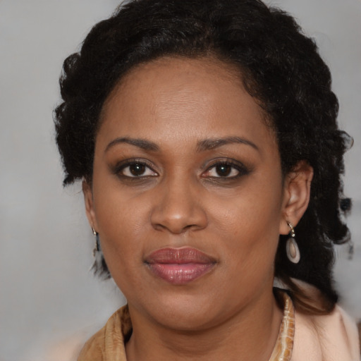 Joyful black adult female with medium  brown hair and brown eyes