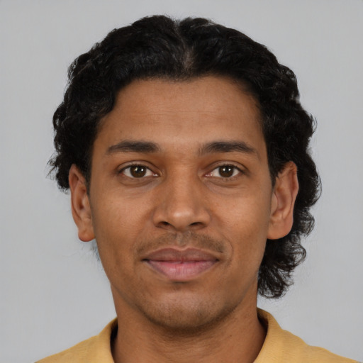 Joyful black young-adult male with short  black hair and brown eyes