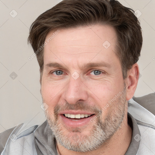 Joyful white adult male with short  brown hair and grey eyes